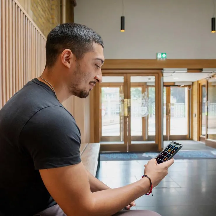 A student looking at the MySMU app on their phone