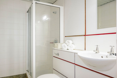 A white en-suite bathroom with a shower, toilet, and sink.