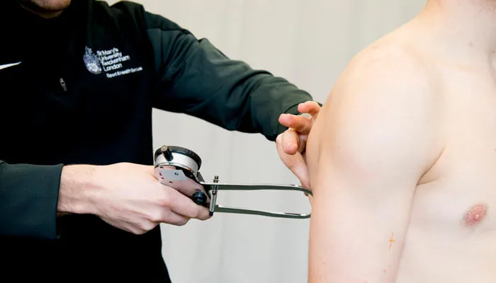 Person using body fat calipers