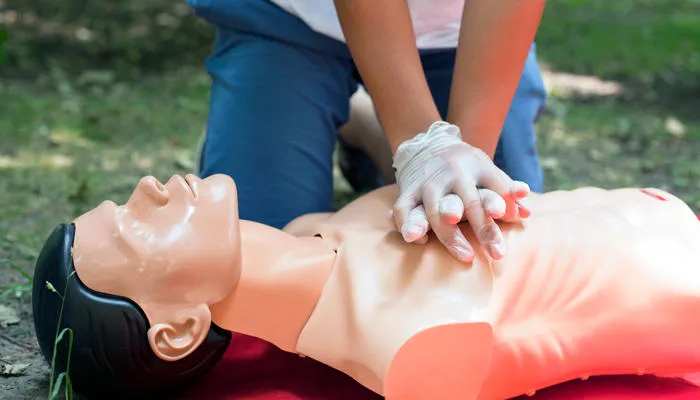 Person performing CPR on a dummy