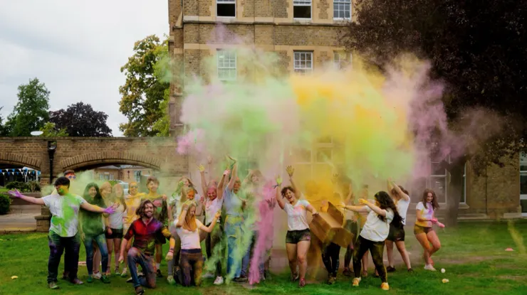 Students celebrate by throwing colourful powder paint on the lawn at St Mary's University.