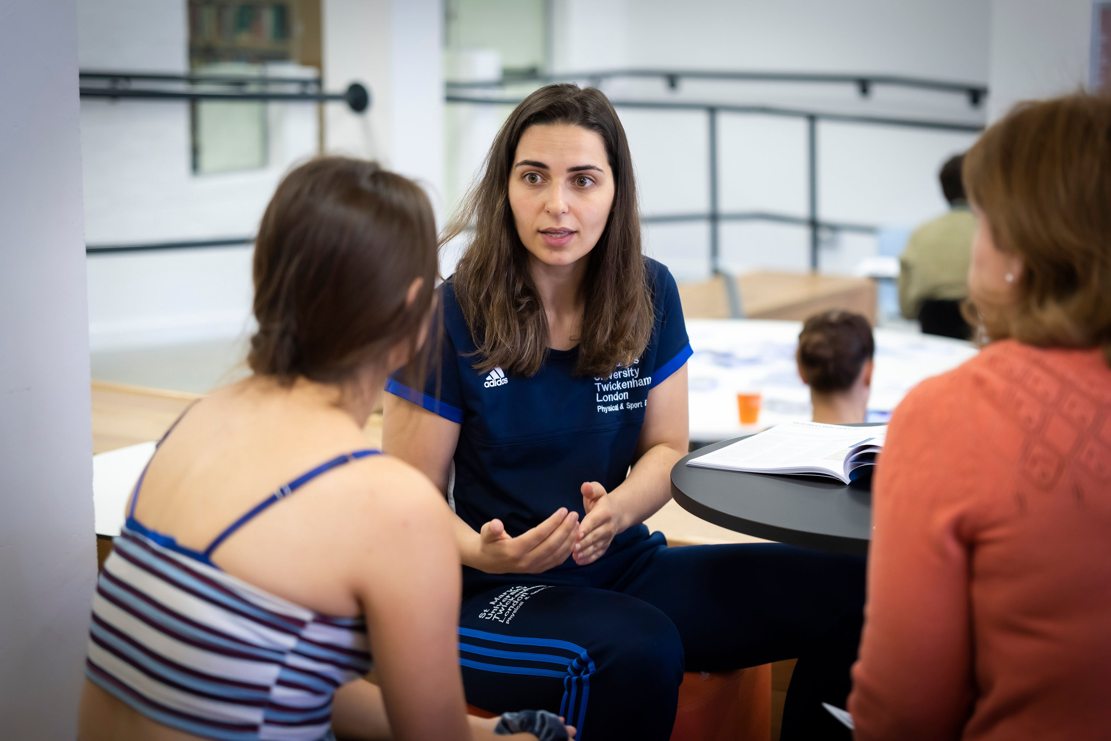 Sports science academic speaking to a prospective student at a St Mary's University Open Day